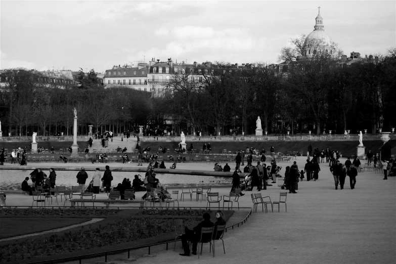 many people walk near a very large pond