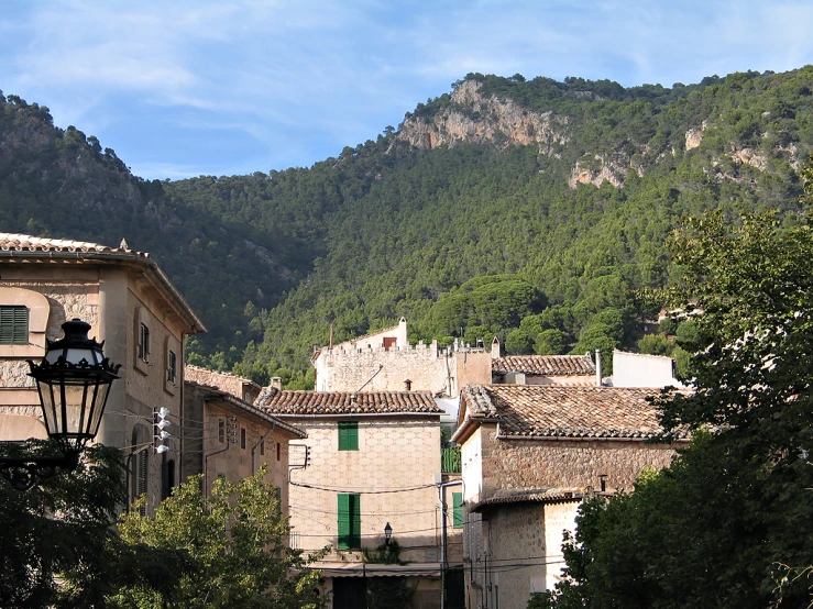 buildings on the side of the street next to a mountain