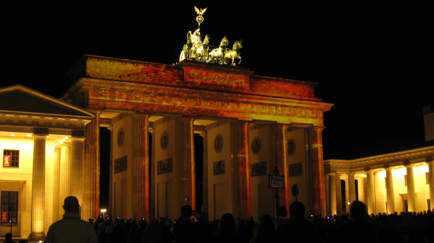 a group of people standing around a big building