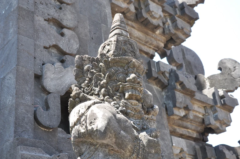 a statue has a head carved on the side of it