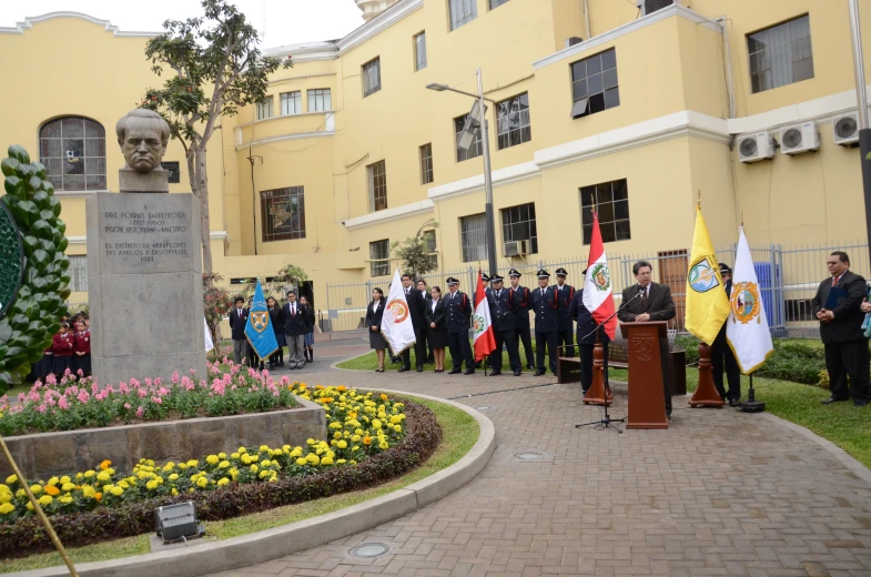 a group of men and women standing at a podium in front of a building