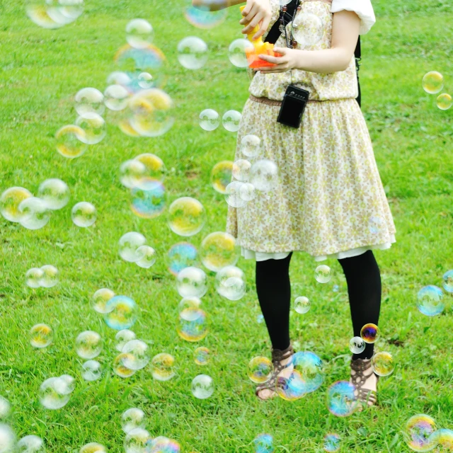 woman holding umbrella and bubble filled field in natural setting