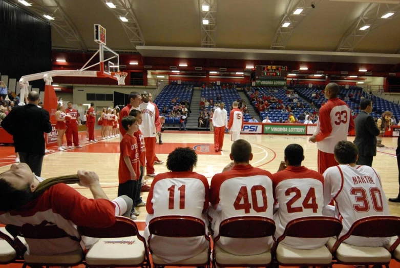 some men are sitting on the court with one another and watching the game