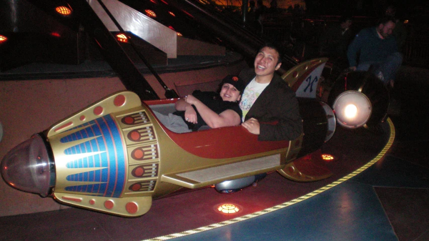 people in a toy car riding on the ground