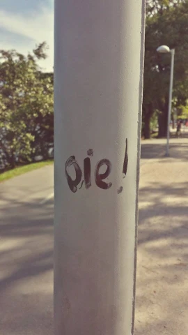 graffiti on the side of a pole near a road