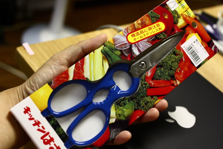 a package with blue scissors and broccoli and some fruit