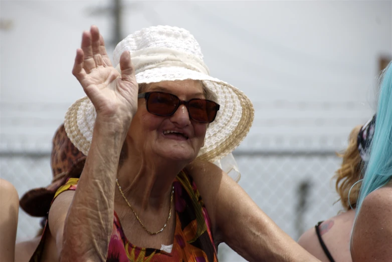 an elderly lady wearing sun glasses and a hat