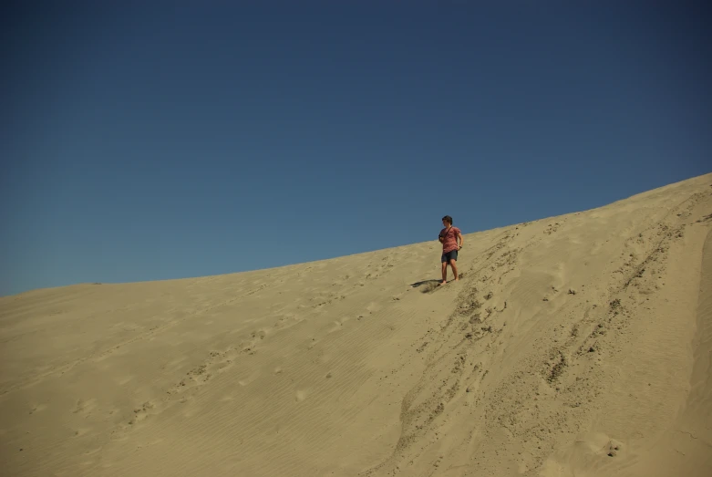 person walking across the sand in the desert