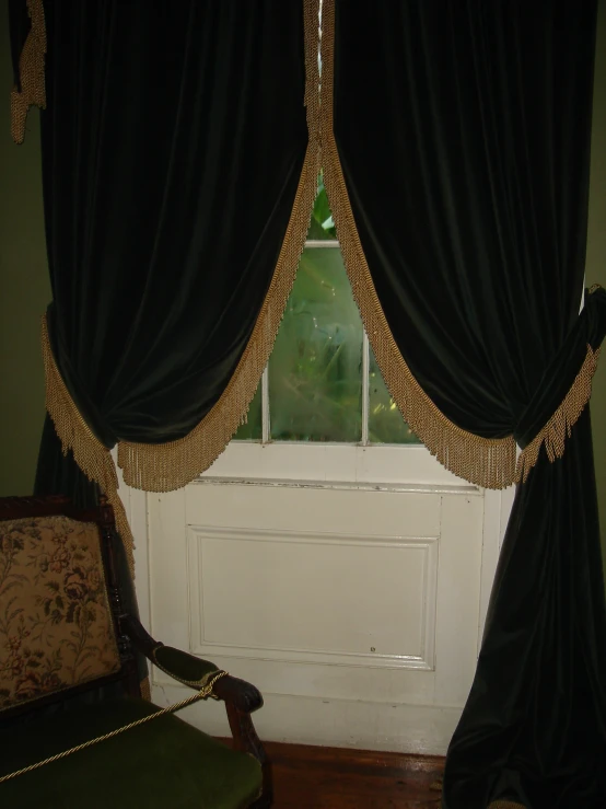 black curtains with gold lace hanging at the window