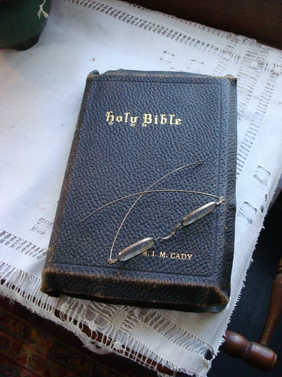 the old book is sitting on top of a tablecloth