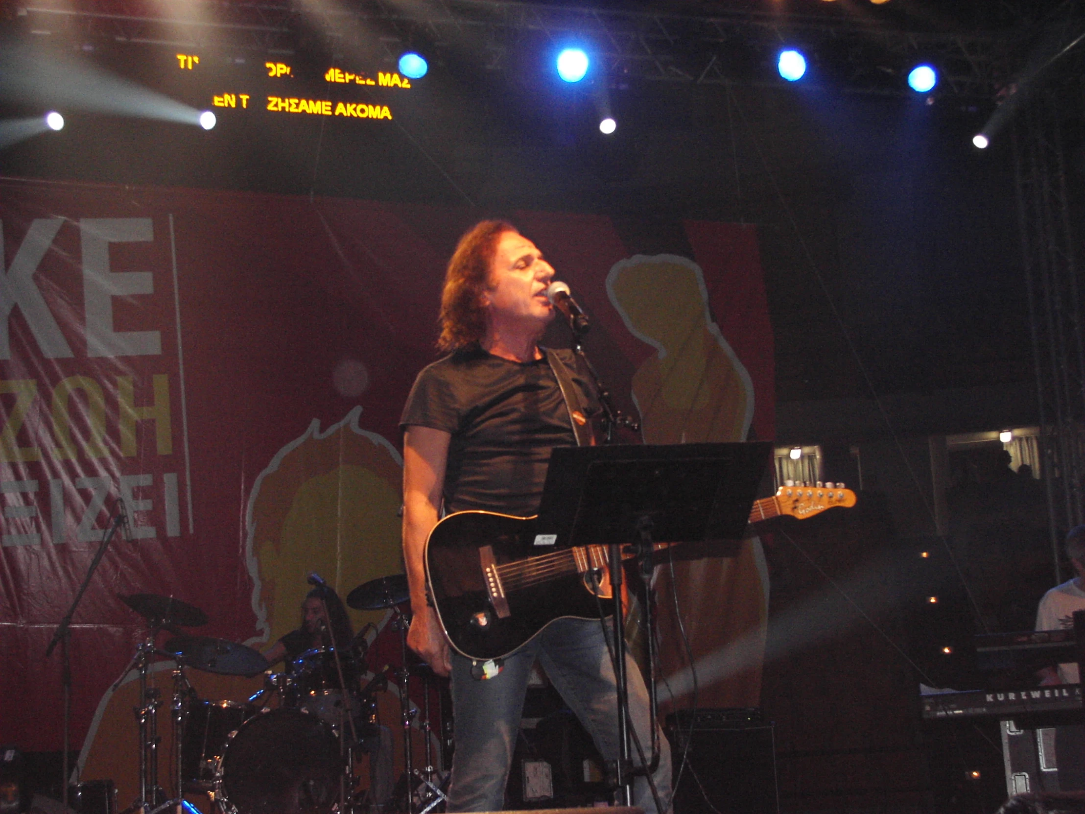 a man holding a microphone and singing into a glass