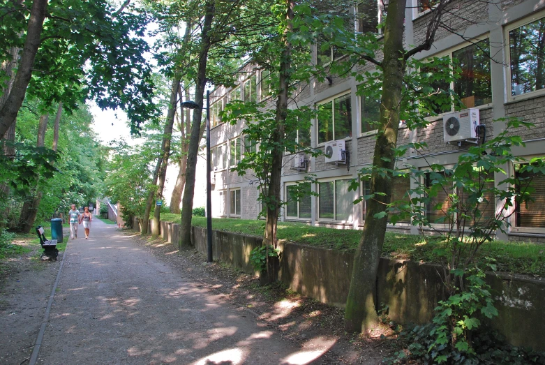 people walk down the pathway at a large residential area