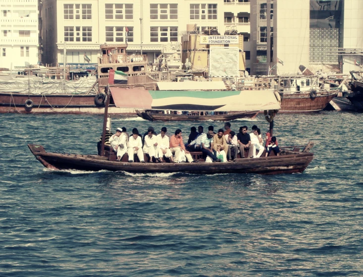a group of people on a small boat with the city in the background