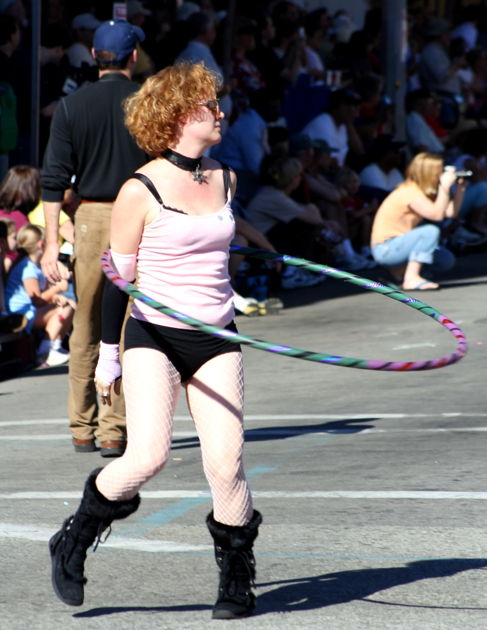 a woman in underwear and a pink top playing with a colorful hula hoop