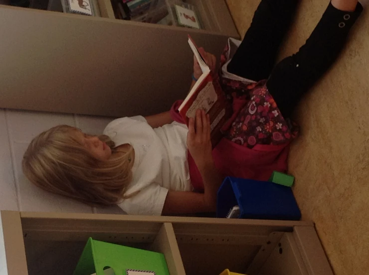 a child sitting on the floor reading a book