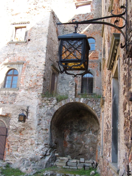 old stone building with open door and lantern above