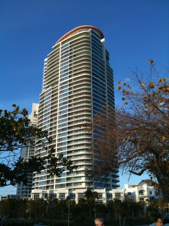 people sitting on the ground in front of a tall building