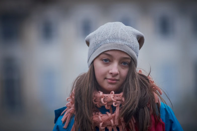  with hat, scarf and jacket against large building