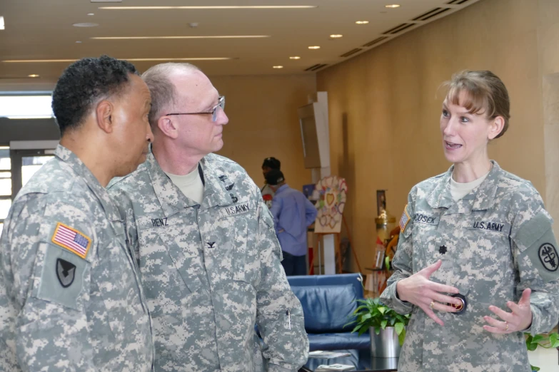 a woman in military uniform standing next to three other men