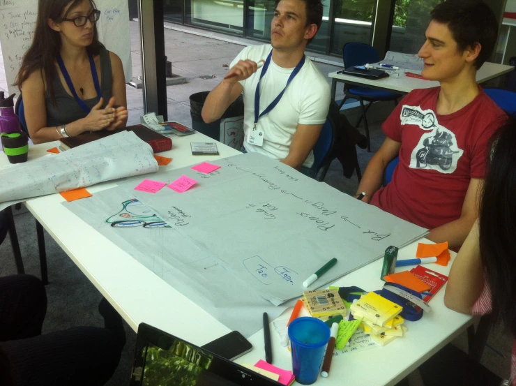 two men and three women sit together at an office table