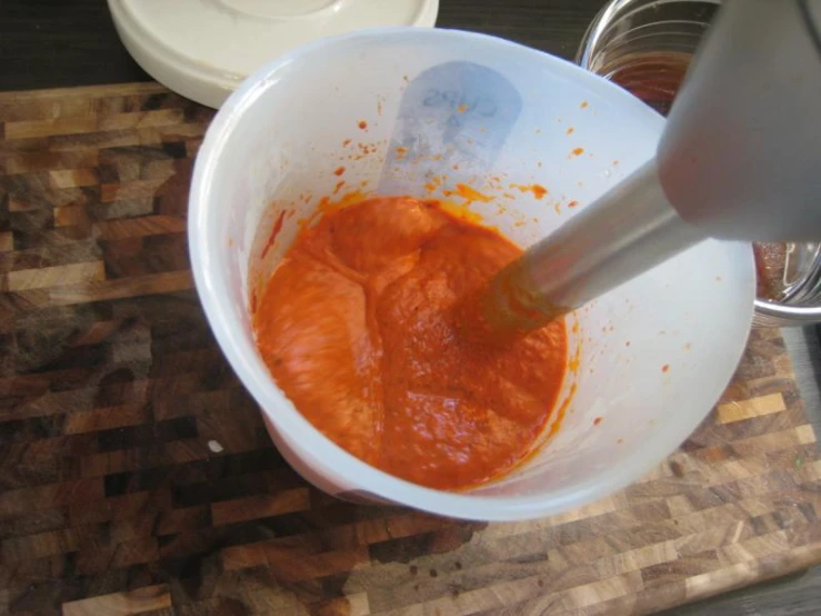 the sauce is being mixed into the batter in a bowl