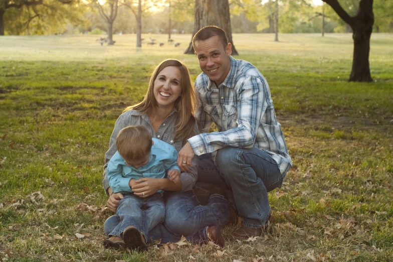 a family posing for a po on a field with trees in the background