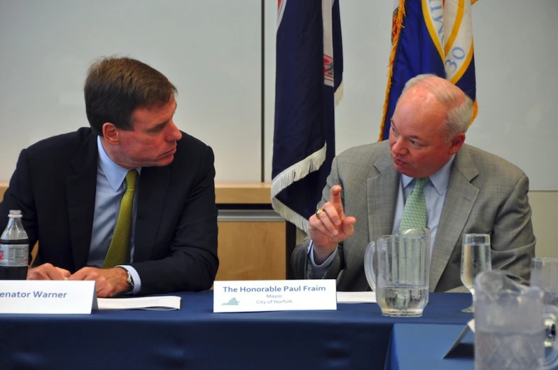 two men sitting at a table talking together