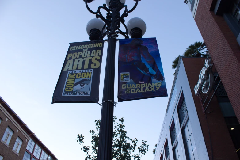 a street light with three banners hanging off it