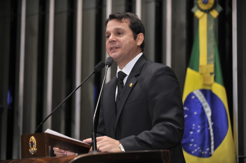 a man standing at a podium with microphone