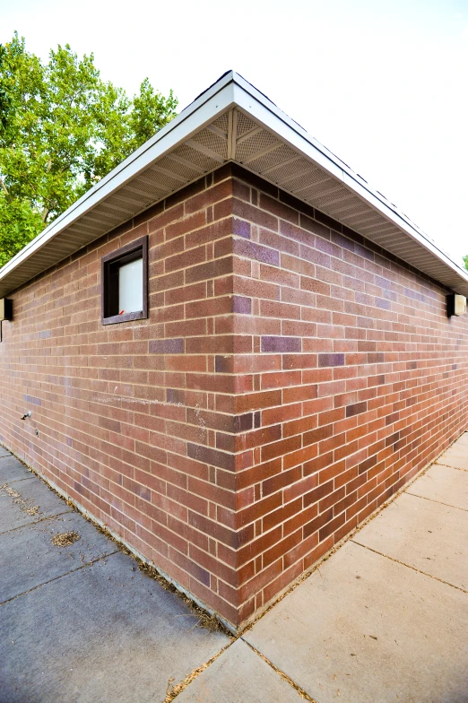 a brick house with a window in a corner