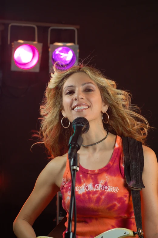 a young woman in a red shirt playing guitar and singing