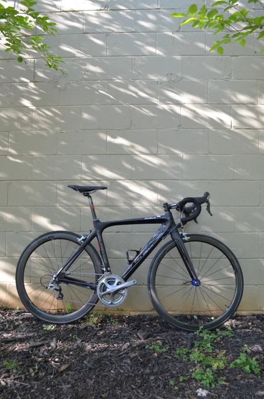 the bike is parked against a wall and leaning against a wall