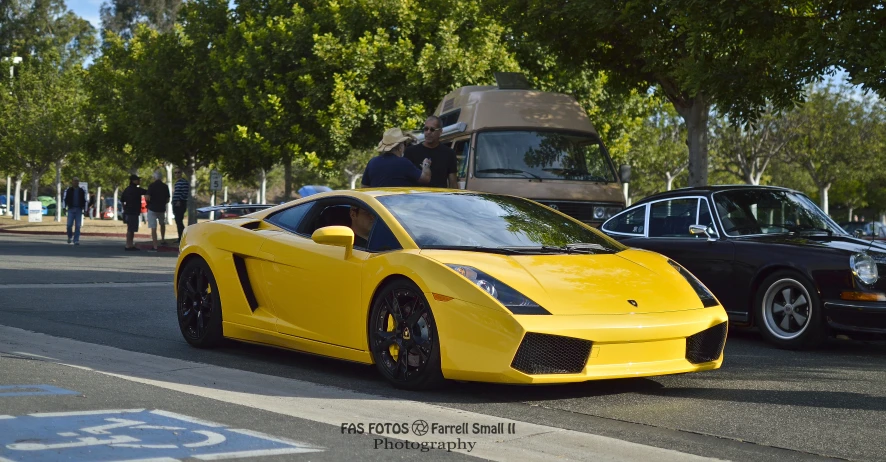 a close up of a yellow sports car on the street