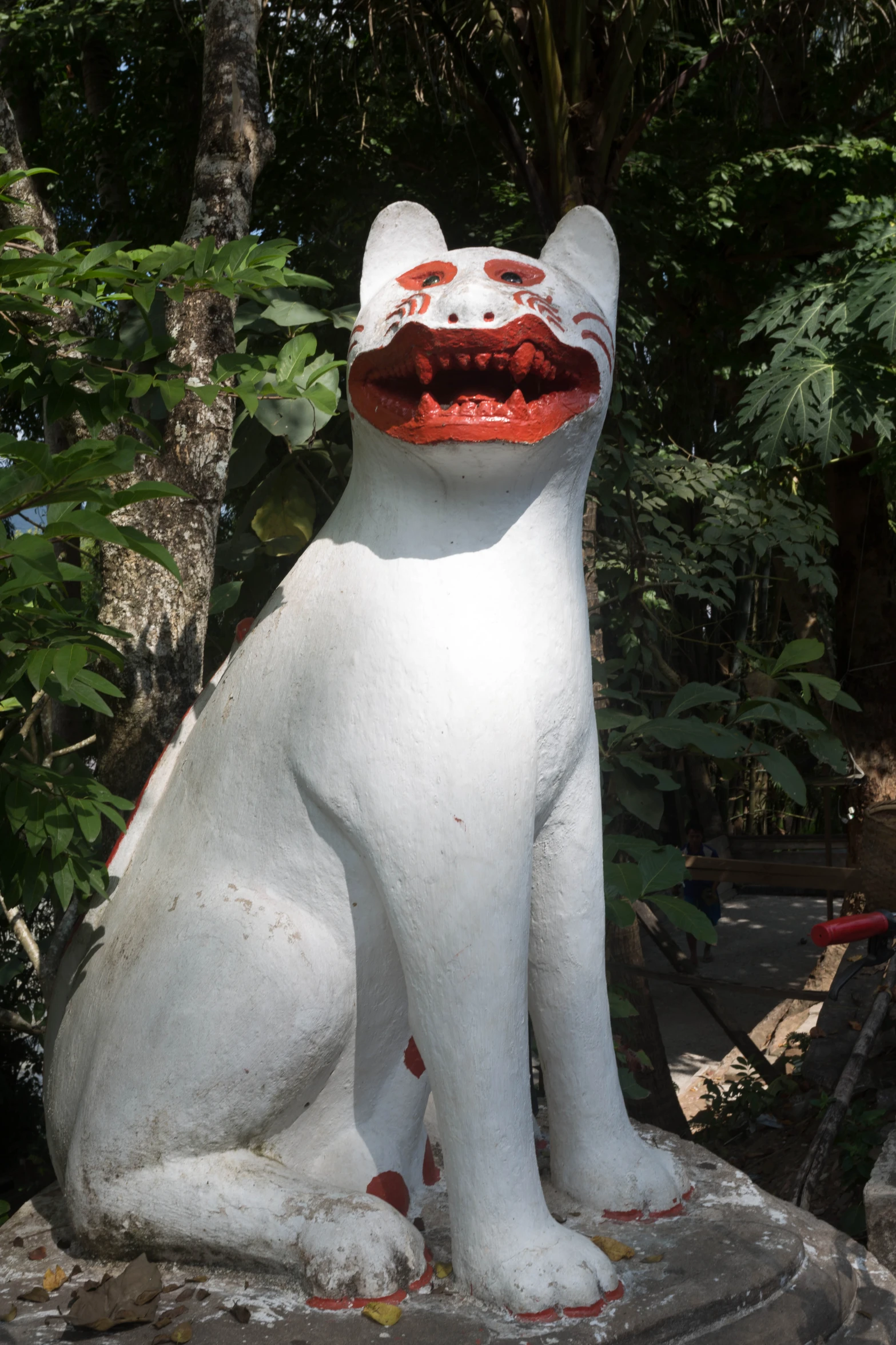 this statue has a fake white cat on its lap