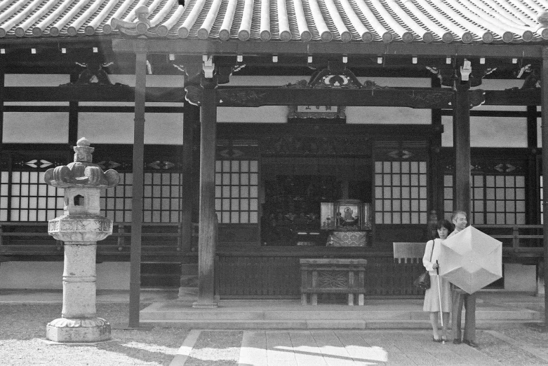 a black and white picture of a man in the japanese courtyard