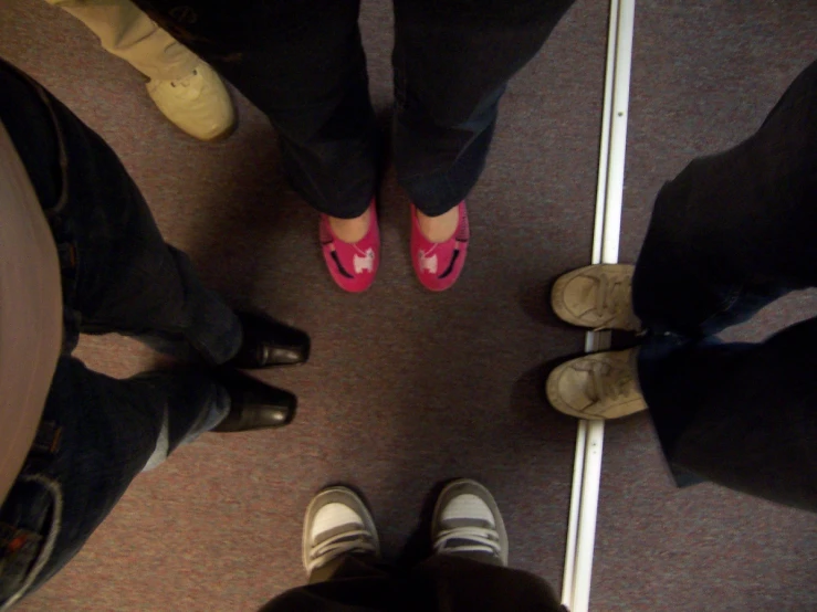 three people in pink and white shoes stand together