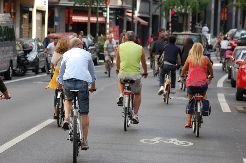 people are riding bikes down the street on a city street