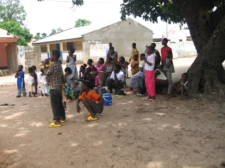 several people gathered around a tree by a house