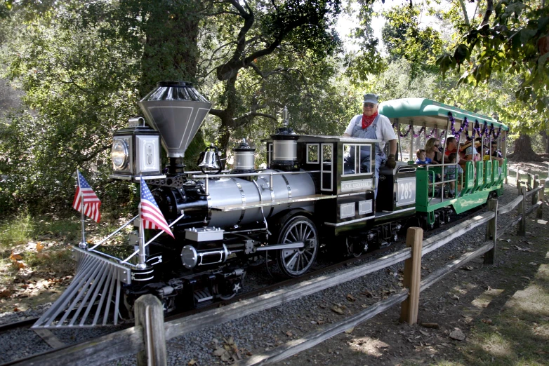 an old fashioned black and green train is coming down the tracks