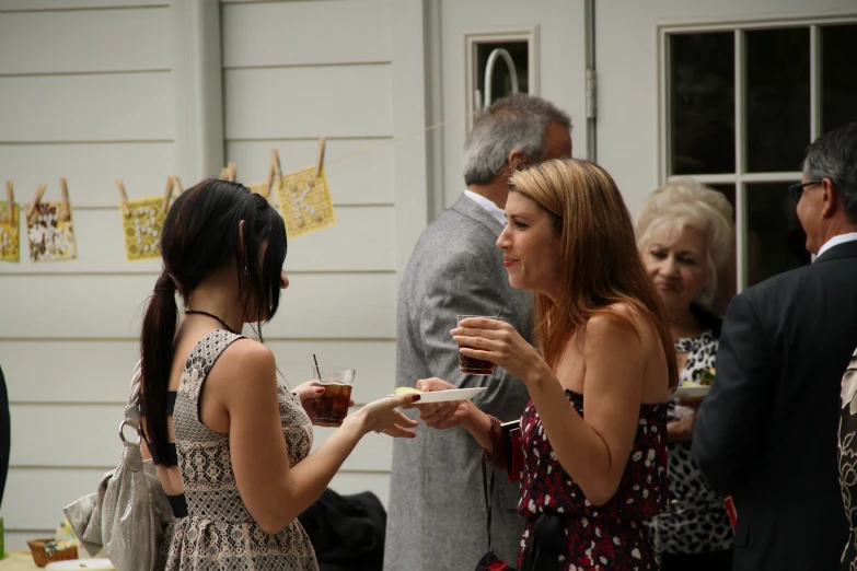 a woman holding a wine glass up to someone else eating