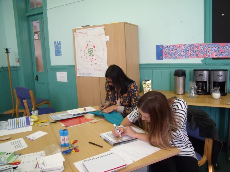 two women working at a table in an office