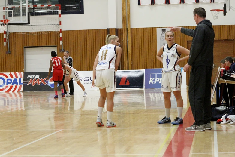 there are some girls playing basketball in a court