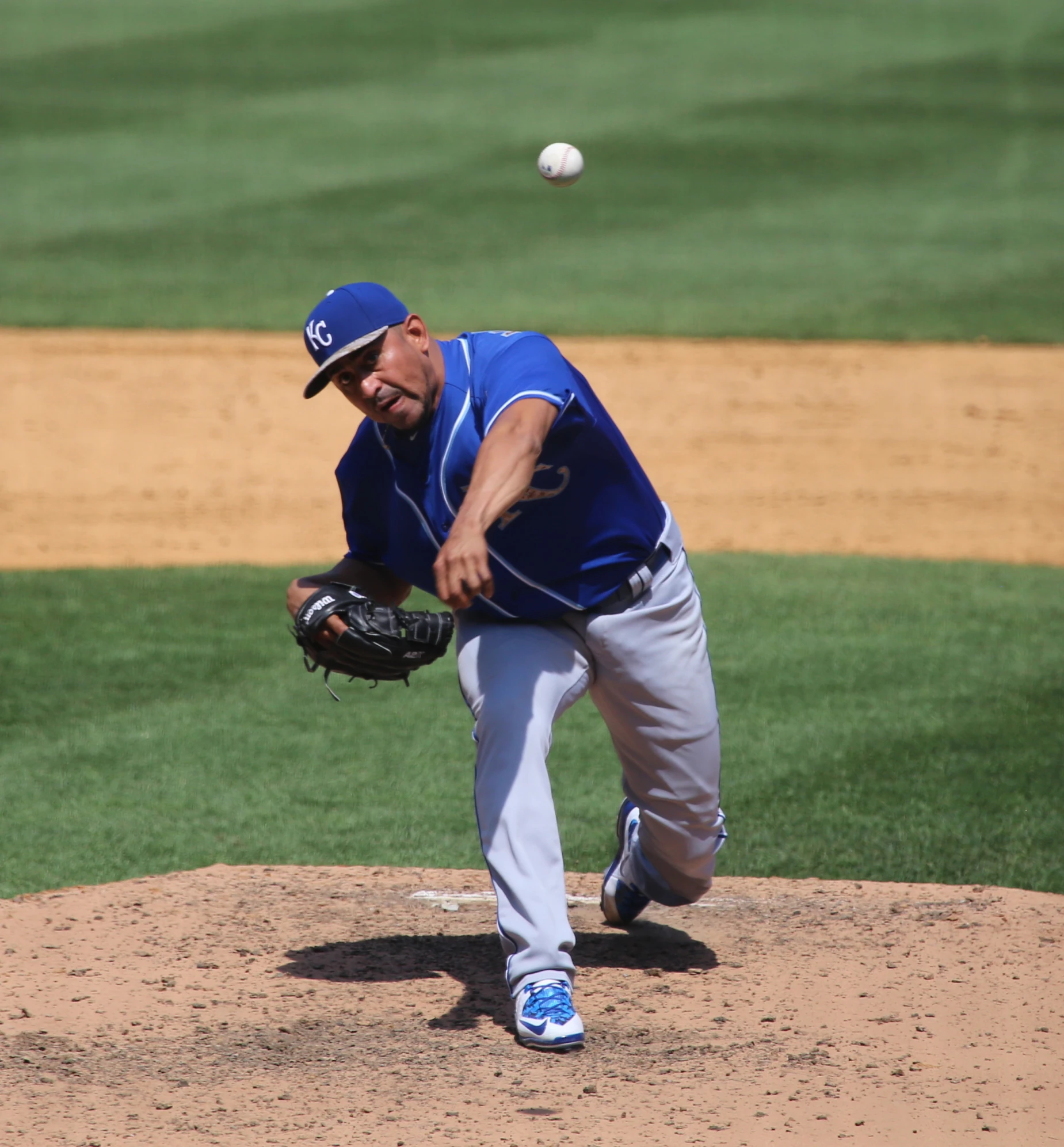 a baseball pitcher on the mound is about to throw the ball