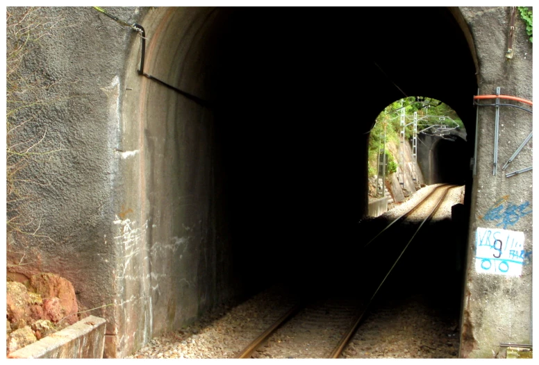 a train traveling through a tunnel under train tracks