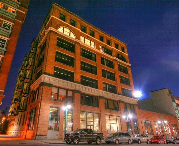 a large red brick building with cars parked in front