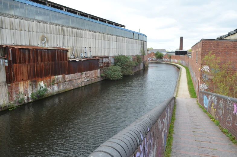 a brick wall is painted brown on the side of a river