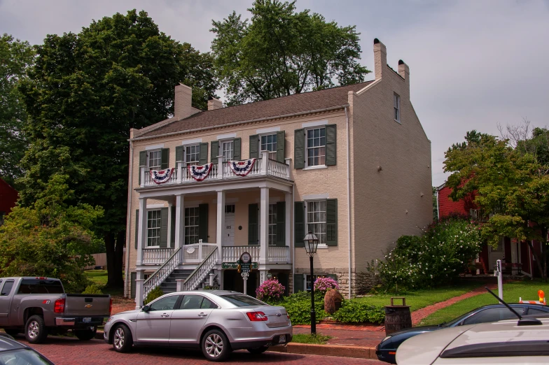 a white car is parked in front of a building with three story windows