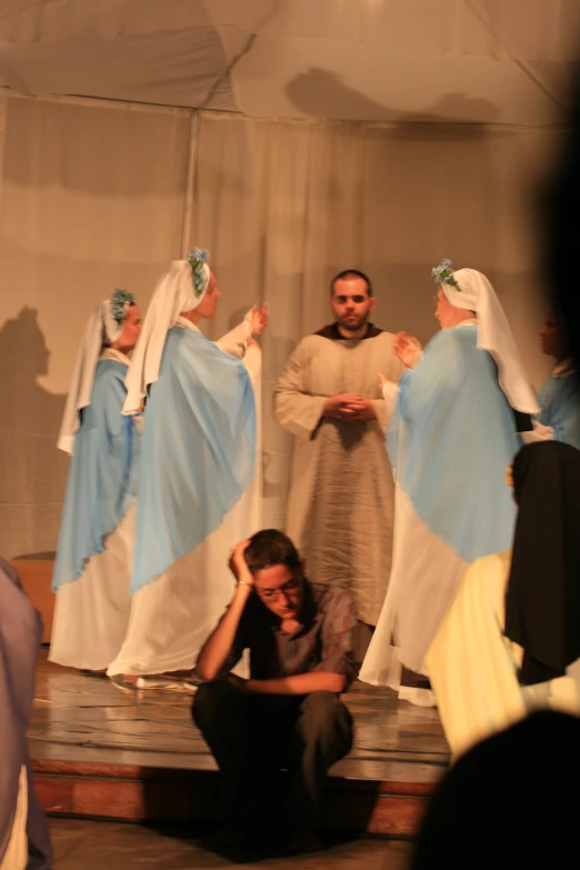 a group of people stand in front of a stage with clothes