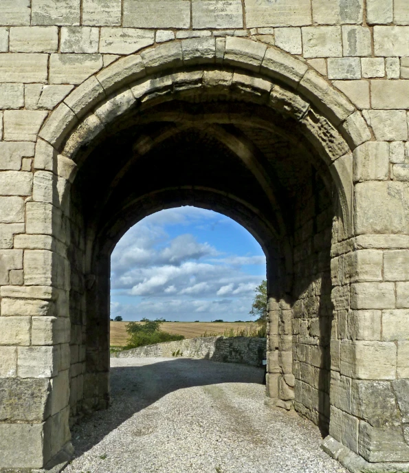 an old stone archway next to a road