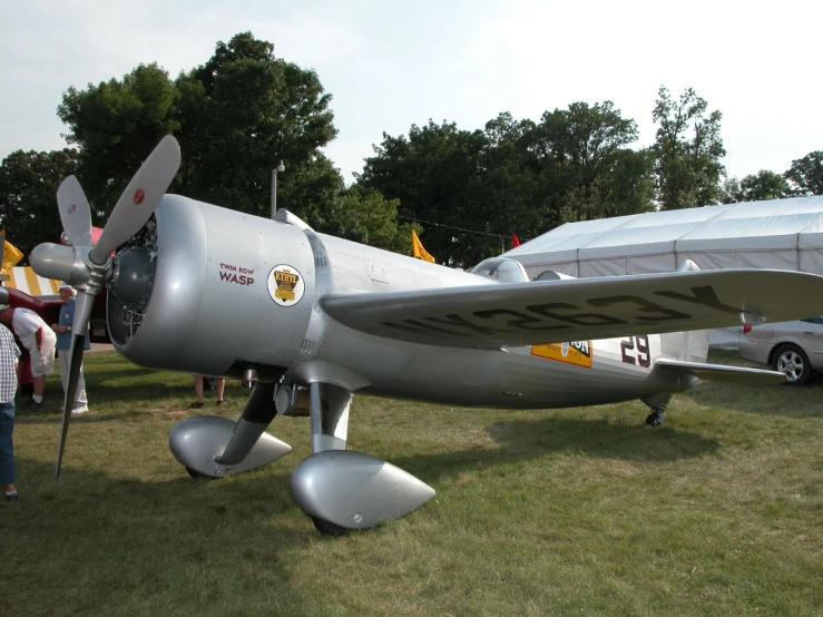 a silver plane that is on some grass
